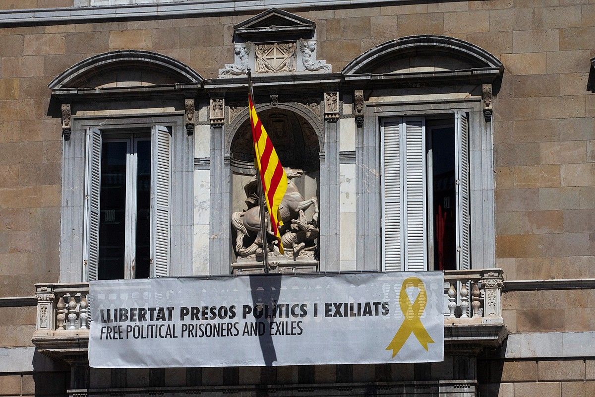Politikari presoak eta erbesteratuak aske uzteko eskatzen duen pankarta dago zintzilik Generalitatean. QUIQUE GARCIA / EFE. Politikari presoak eta erbesteratuak aske uzteko eskatzen duen pankarta dago zintzilik Generalitatean. QUIQUE GARCIA / EFE.