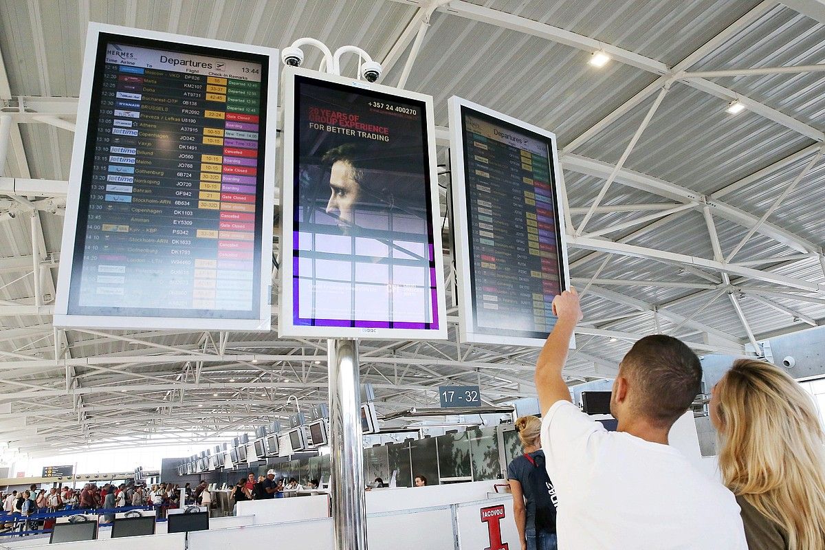 Turistak Zipreko aireportuan, atzo, hegaldiei begira. KATIA CHRISTODOULOU / EFE.