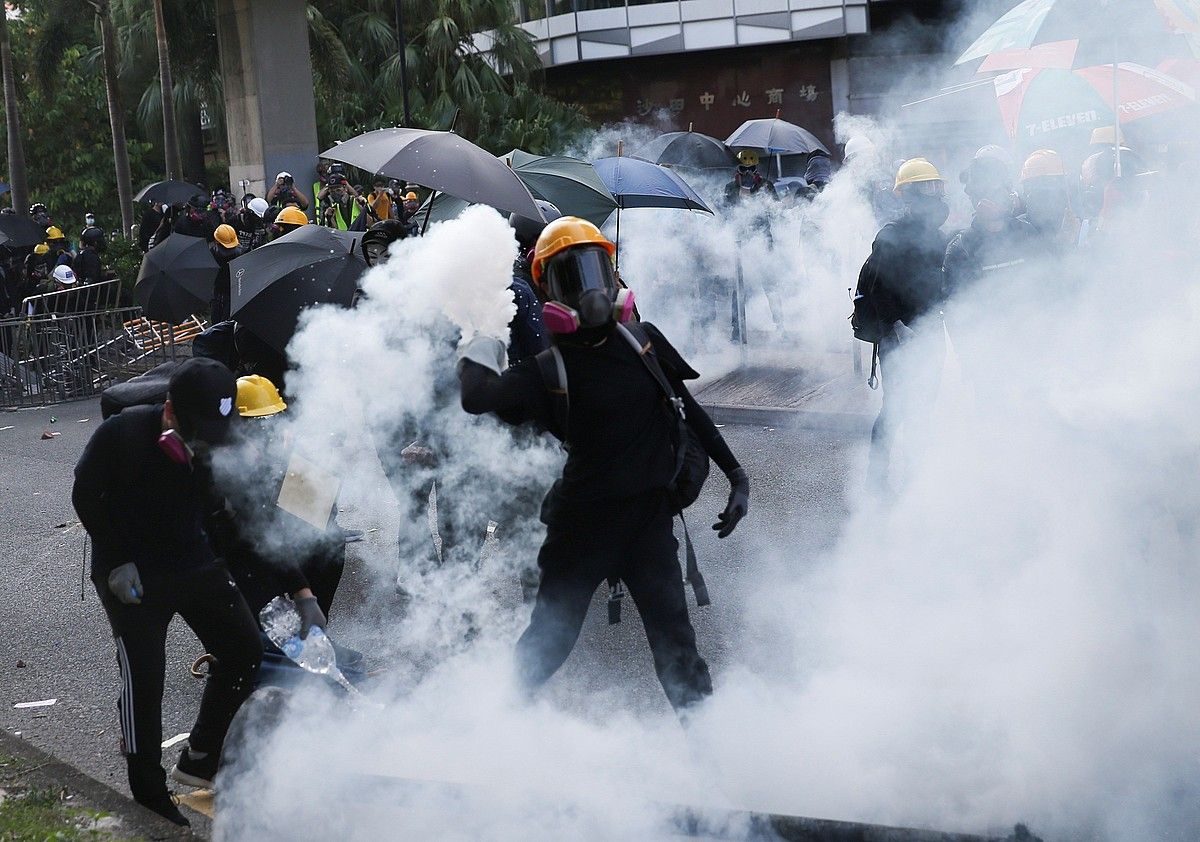Gobernuaren aurkako manifestariak Poliziak jaurtitako gasaren artean, atzo, Hong Kongen. JEROME FAVRE / EFE. Gobernuaren aurkako manifestariak Poliziak jaurtitako gasaren artean, atzo, Hong Kongen. JEROME FAVRE / EFE.