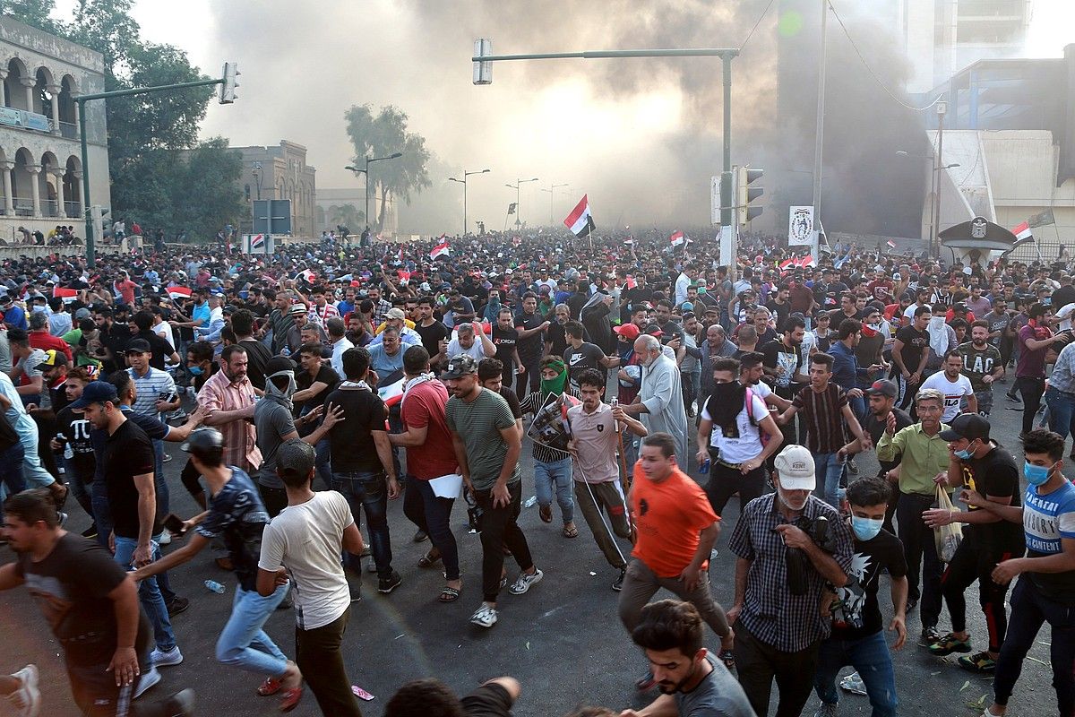 Herritarrak manifestazio batean, Bagdaden, asteartean, Poliziak negar egiteko gasa jaurti zuen unean. AHMED JALIL / EFE.