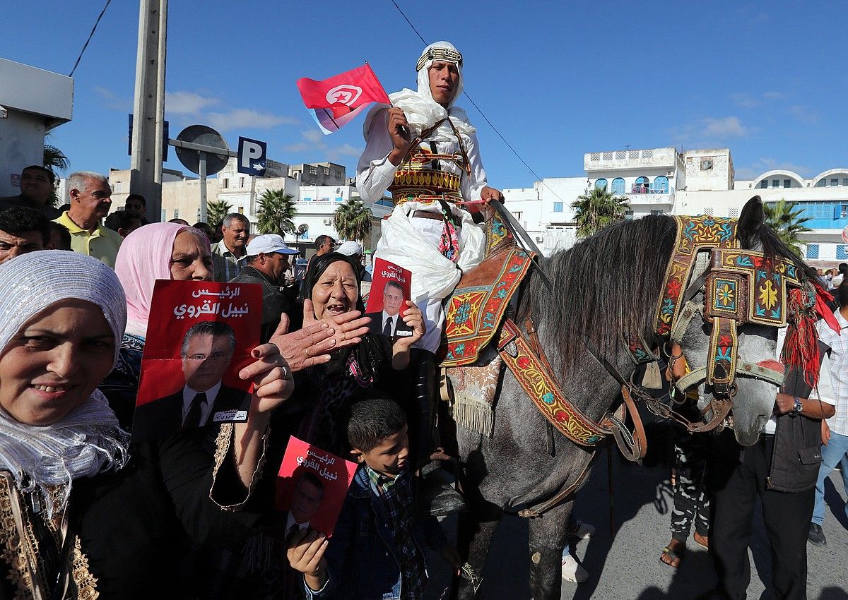 Nabil Karui presidentegaiaren jarraitzaileak herenegun, kanpainako azken egunean, iparraldeko kostako Bizerte hirian. MOHAMED MESSARA / EFE.
