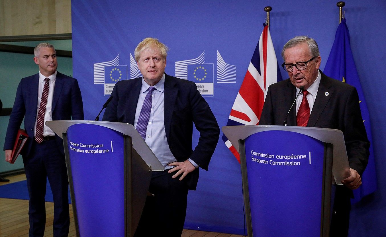 Johnson Erresuma Batuko lehen ministroa eta Juncker Europako Batzordeko presidentea elkarri eskua ematen, atzo, Bruselan. OLIVIER HOSLET / EFE.