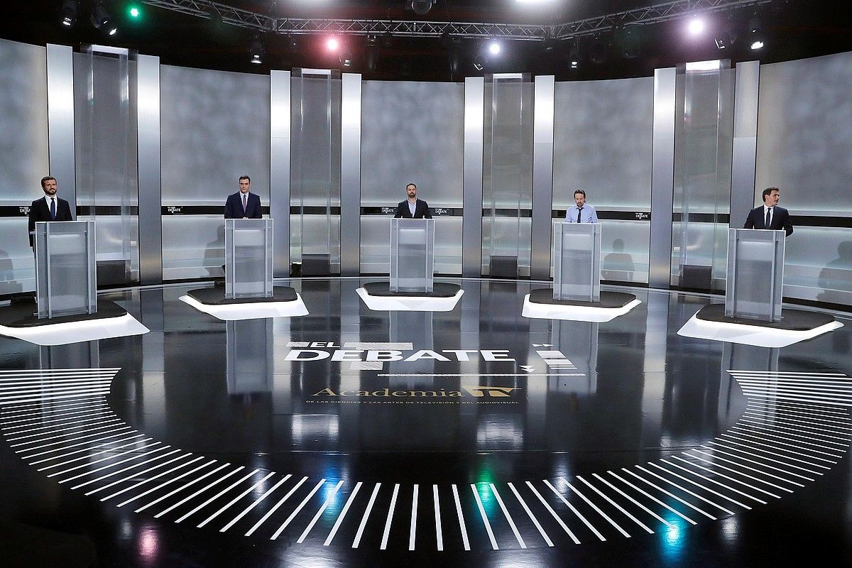 Bost hautagaiak zutik eta atril banaren aurrean aritu ziren astelehen gaueko debatean. JUAN CARLOS HIDALGO / EFE. Bost hautagaiak zutik eta atril banaren aurrean aritu ziren astelehen gaueko debatean. JUAN CARLOS HIDALGO / EFE.