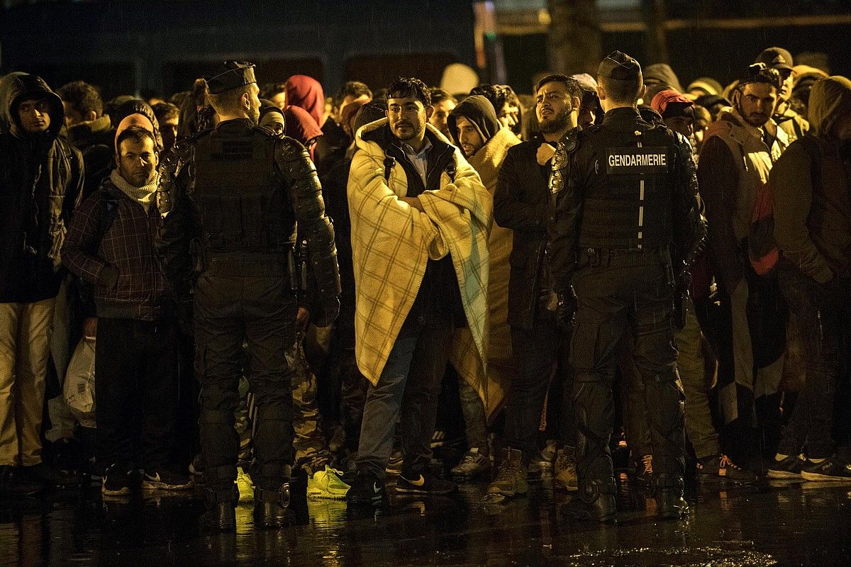 Migratzaileetako batzuk, jendarmeak parean dituztela, atzo goizaldean, Parisen. Ile-de-France eskualdeko hamabost gimnasiotara eraman zituzten. J. DE ROSA / EFE. Migratzaileetako batzuk, jendarmeak parean dituztela, atzo goizaldean, Parisen. Ile-de-France eskualdeko hamabost gimnasiotara eraman zituzten. J. DE ROSA / EFE.