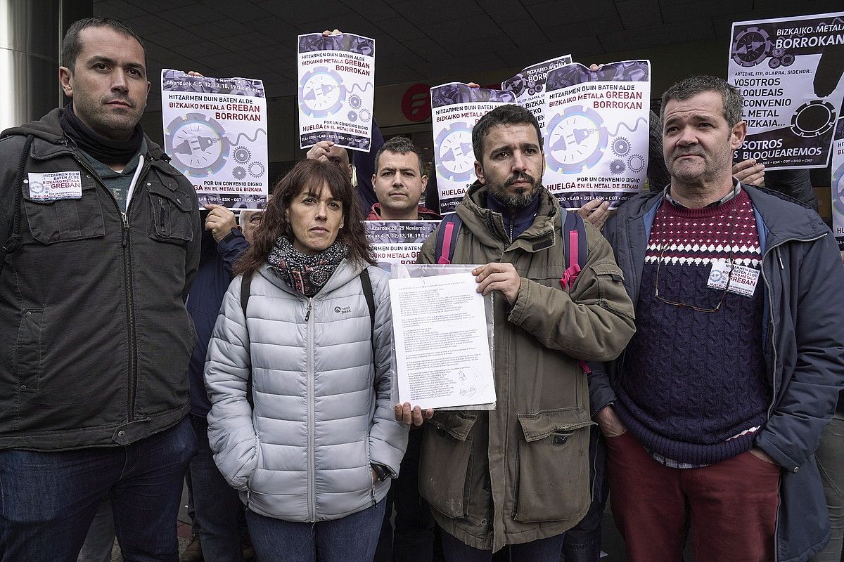 Bizkaiko metalgintzako sindikatuetako ordezkariak FVEMen egoitzaren aurrean, atzo, grebaren jakinarazpen ofizialaren agiriarekin. MONIKA DEL VALLE / FOKU. Bizkaiko metalgintzako sindikatuetako ordezkariak FVEMen egoitzaren aurrean, atzo, grebaren jakinarazpen ofizialaren agiriarekin. MONIKA DEL VALLE / FOKU.