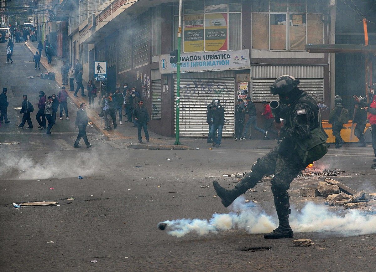 Polizia bat eta manifestariak, atzo La Paz hiriburuko istiluetan. MARTIN ALIPAZ / EFE.