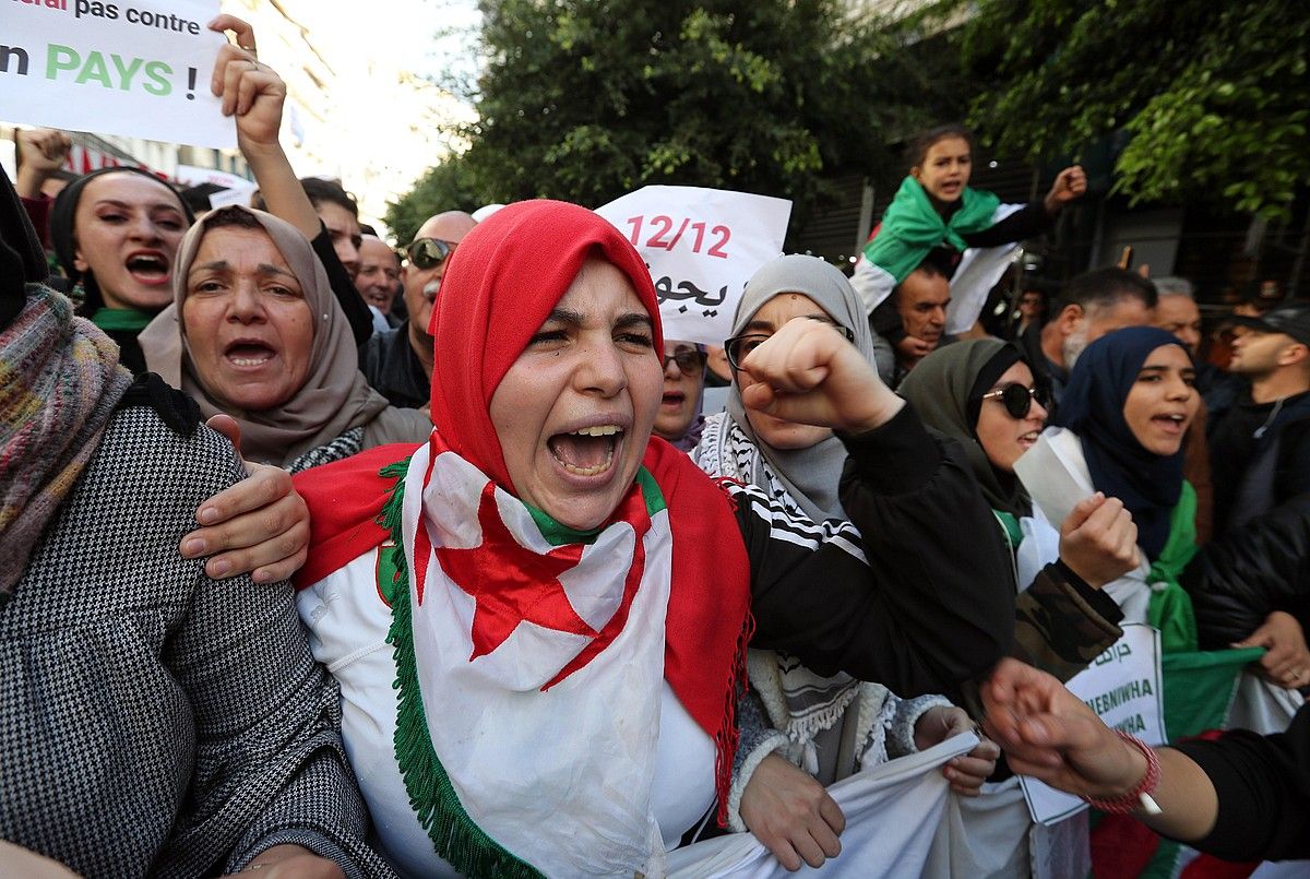 Azken hamar hilabeteetan manifestariak astero irten dira kalera Aljerian, erregimen zaharra behin betiko amai dadila eskatzeko. MOHAMED MESSARA / EFE. Azken hamar hilabeteetan manifestariak astero irten dira kalera Aljerian, erregimen zaharra behin betiko amai dadila eskatzeko. MOHAMED MESSARA / EFE.