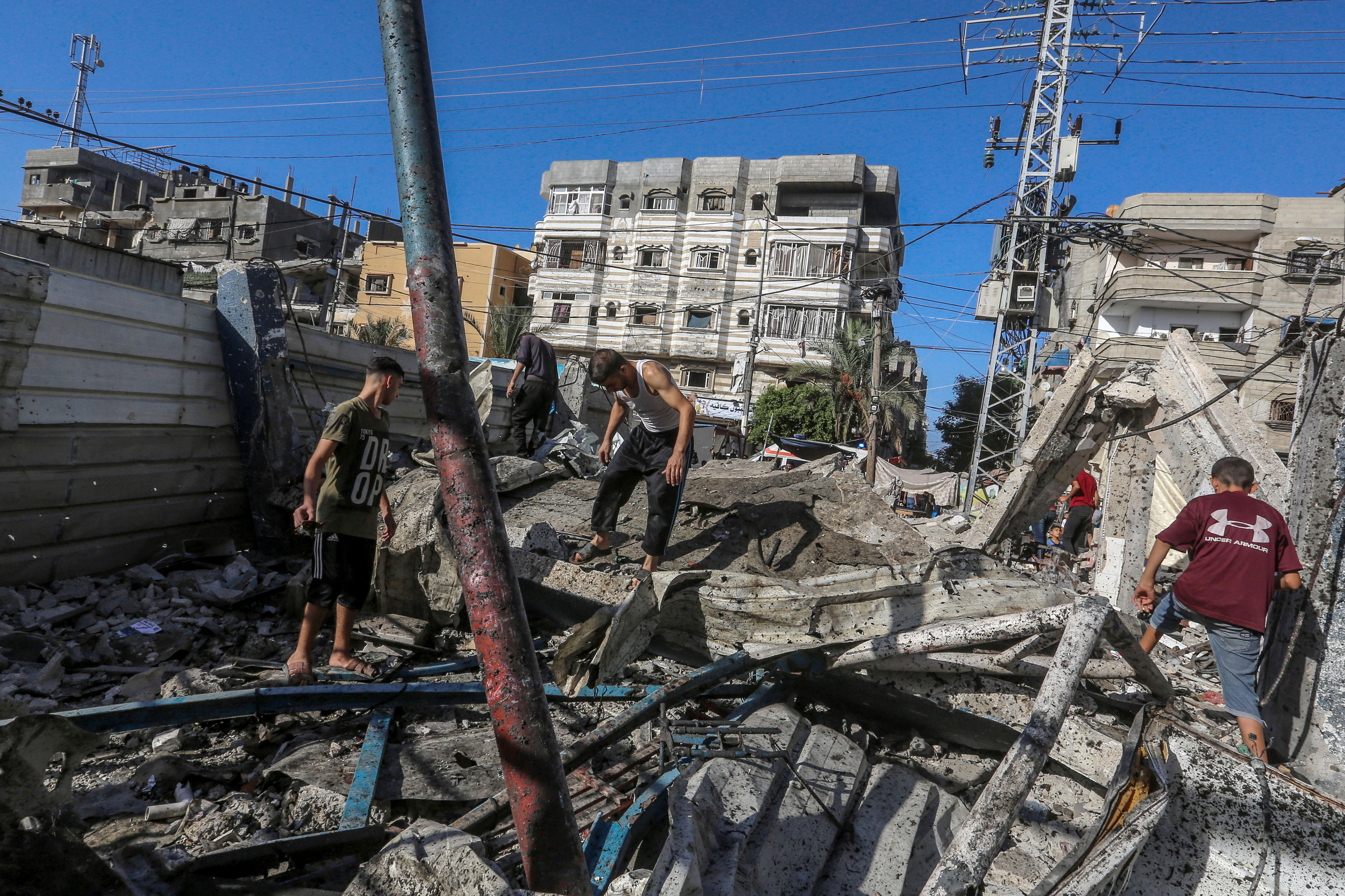 Zenbait palestinar Israelgo armadak bonbardatutako Al-Nuiserat eskolan, atzo, Gaza erdialdean. MOHAMMED SABER / EFE
