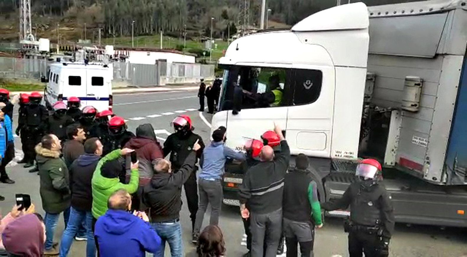 Kamioiak Araluceko materialarekin eta langileak protestan, atzo. BERRIA.