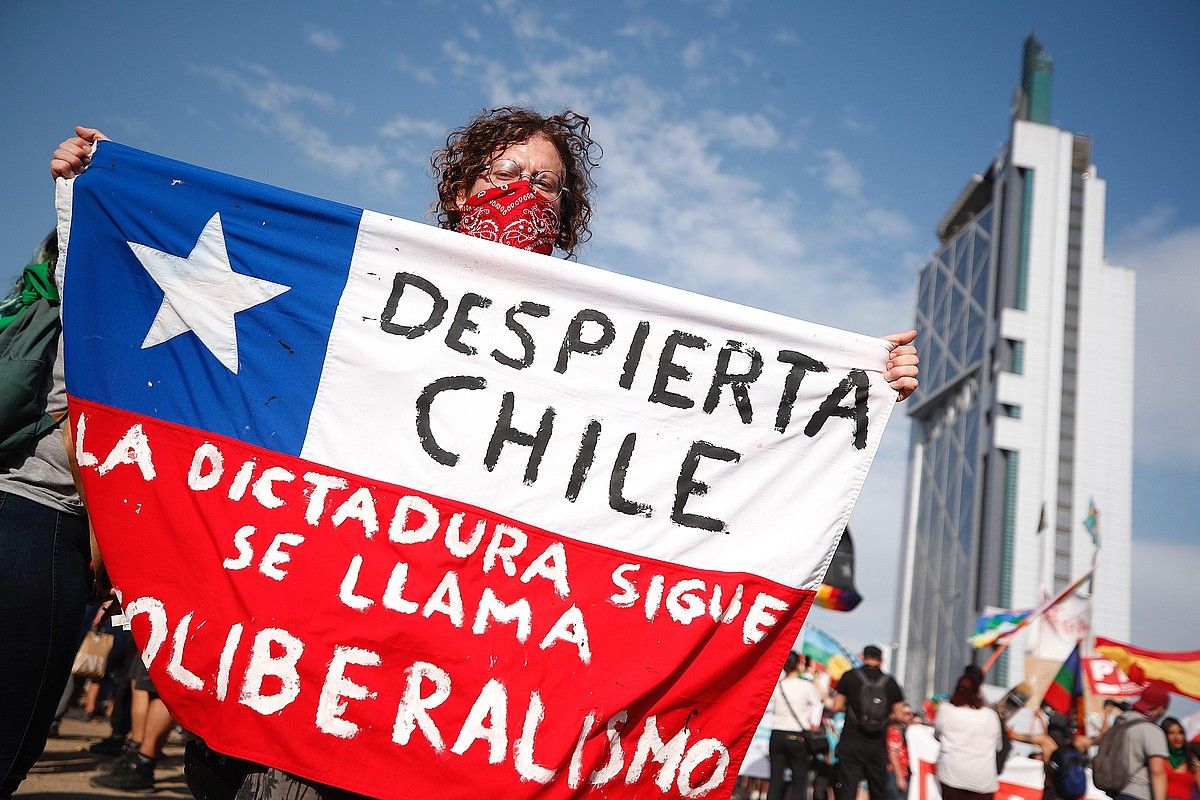 Manifestari bat, milaka lagun bildu zituen protestetako batean, Duintasunaren plazan, Santiagon, abenduaren 6an. ALBERTO VALDES / EFE. Manifestari bat, milaka lagun bildu zituen protestetako batean, Duintasunaren plazan, Santiagon, abenduaren 6an. ALBERTO VALDES / EFE.