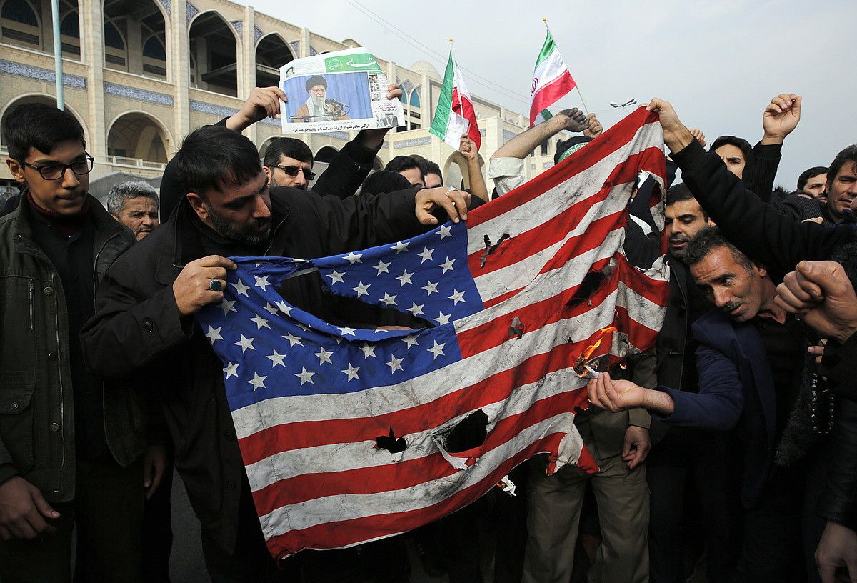 Soleimaniren hilketaren aurkako protestak, atzo, Teheranen. Ameriketako Estatu Batuetako banderak erre zituzten herritarrek. ABEDIN TAHERKENAREH / EFE. Soleimaniren hilketaren aurkako protestak, atzo, Teheranen. Ameriketako Estatu Batuetako banderak erre zituzten herritarrek. ABEDIN TAHERKENAREH / EFE.