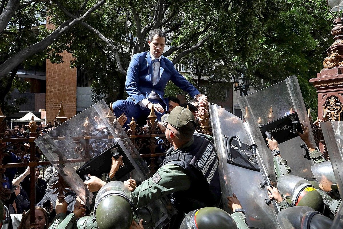 Guaido oposizioko burua parlamentura sartzen saiatu zen igandean, burdin hesira igota. RAYNER PEÑA / EFE.