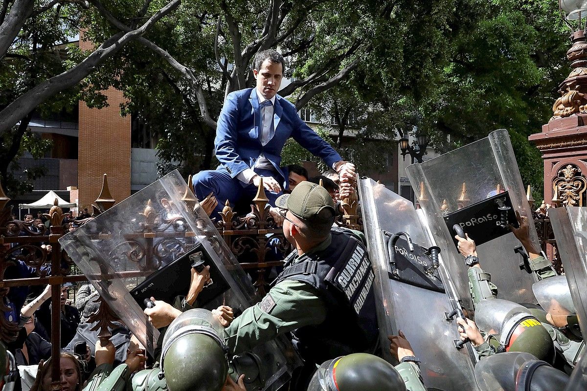 Guaido oposizioko burua parlamentura sartzen saiatu zen igandean, burdin hesira igota. RAYNER PEÑA / EFE. Guaido oposizioko burua parlamentura sartzen saiatu zen igandean, burdin hesira igota. RAYNER PEÑA / EFE.