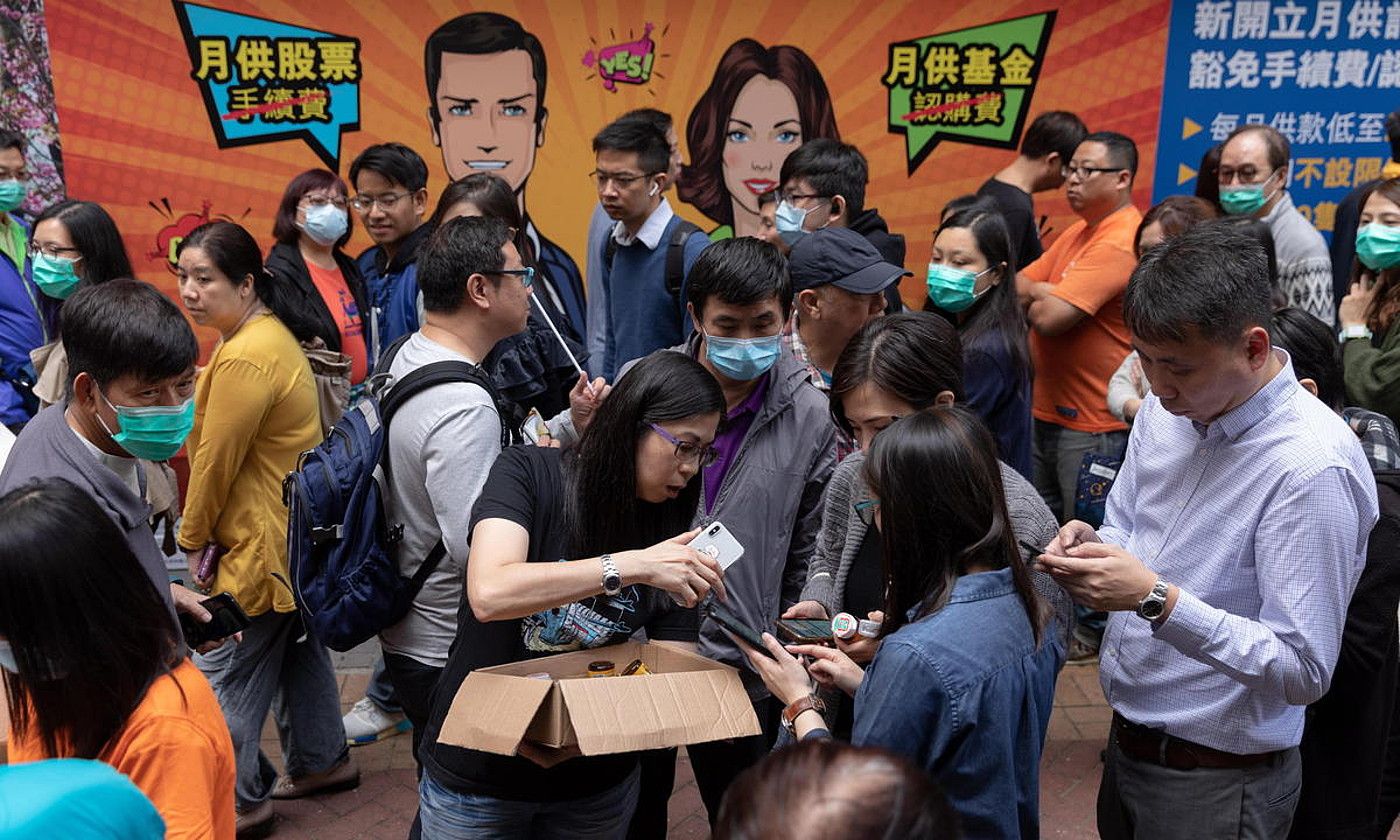 Herritarrek ilara luzeak egin zituzten atzo Hong Kongen Ci bitaminadun pilulak eta ur botilak jasotzeko. JEROME FAVRE / EFE. Herritarrek ilara luzeak egin zituzten atzo Hong Kongen Ci bitaminadun pilulak eta ur botilak jasotzeko. JEROME FAVRE / EFE.