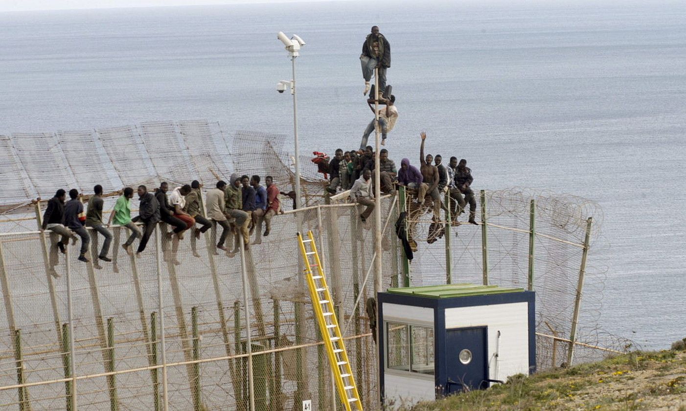Hainbat migratzaile Melillako hesia igarotzen saiatzen. PACO F. GUERRERO / EFE. Hainbat migratzaile Melillako hesia igarotzen saiatzen. PACO F. GUERRERO / EFE.
