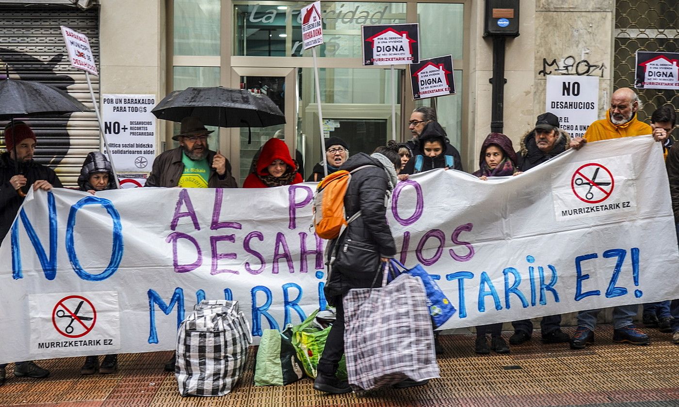 Kaleratutako emakumearen gertukoak poltsak etxebizitzatik jaisten, besteak protestan ari diren bitartean. MARISOL RAMIREZ / FOKU.