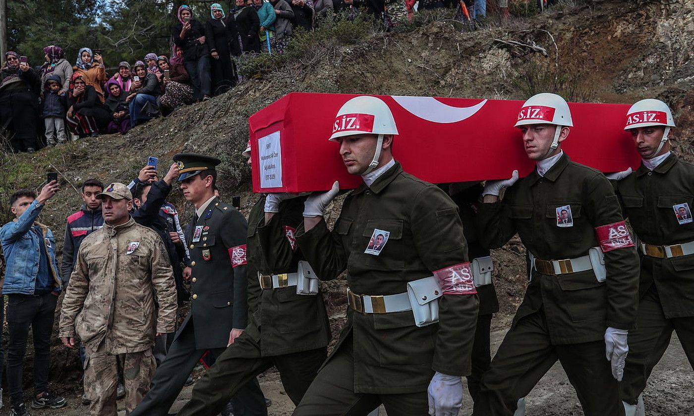 Turkiako polizia militar talde bat, joan den ostiralean, Siriak Idliben egindako aire eraso batean hildako soldadu baten hilkutxa garraiatzen, Turkiako Gulderen herrian. SEDAT SUNA / EFE.