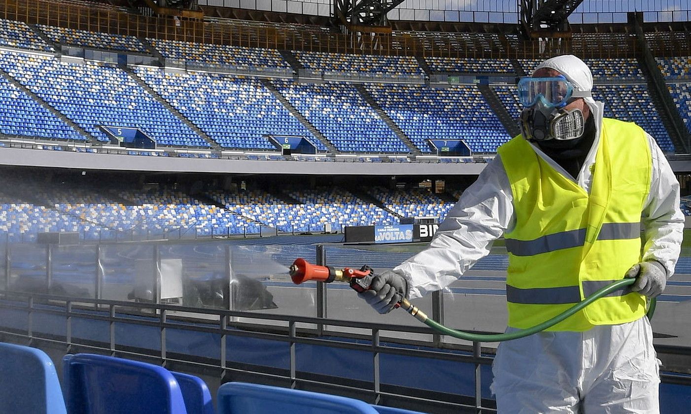 Langile bat koronabirusarengatik Napoliko San Paolo estadioa garbitzen, atzo, Italian. CIRO FUSCO / EFE.