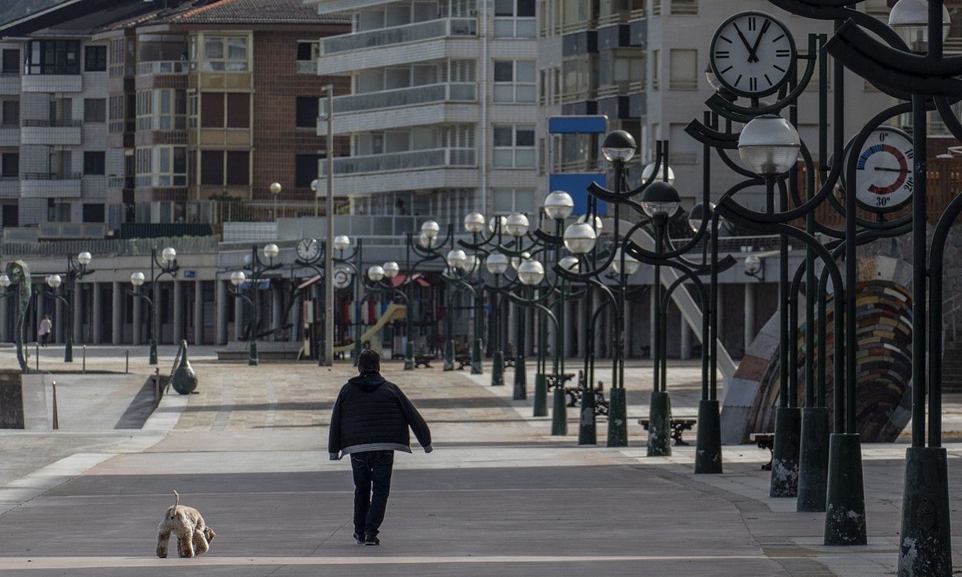 Pertsona bat txakurrarekin paseatzen, Zarauzko malekoian. JON URBE / FOKU. Pertsona bat txakurrarekin paseatzen, Zarauzko malekoian. JON URBE / FOKU.