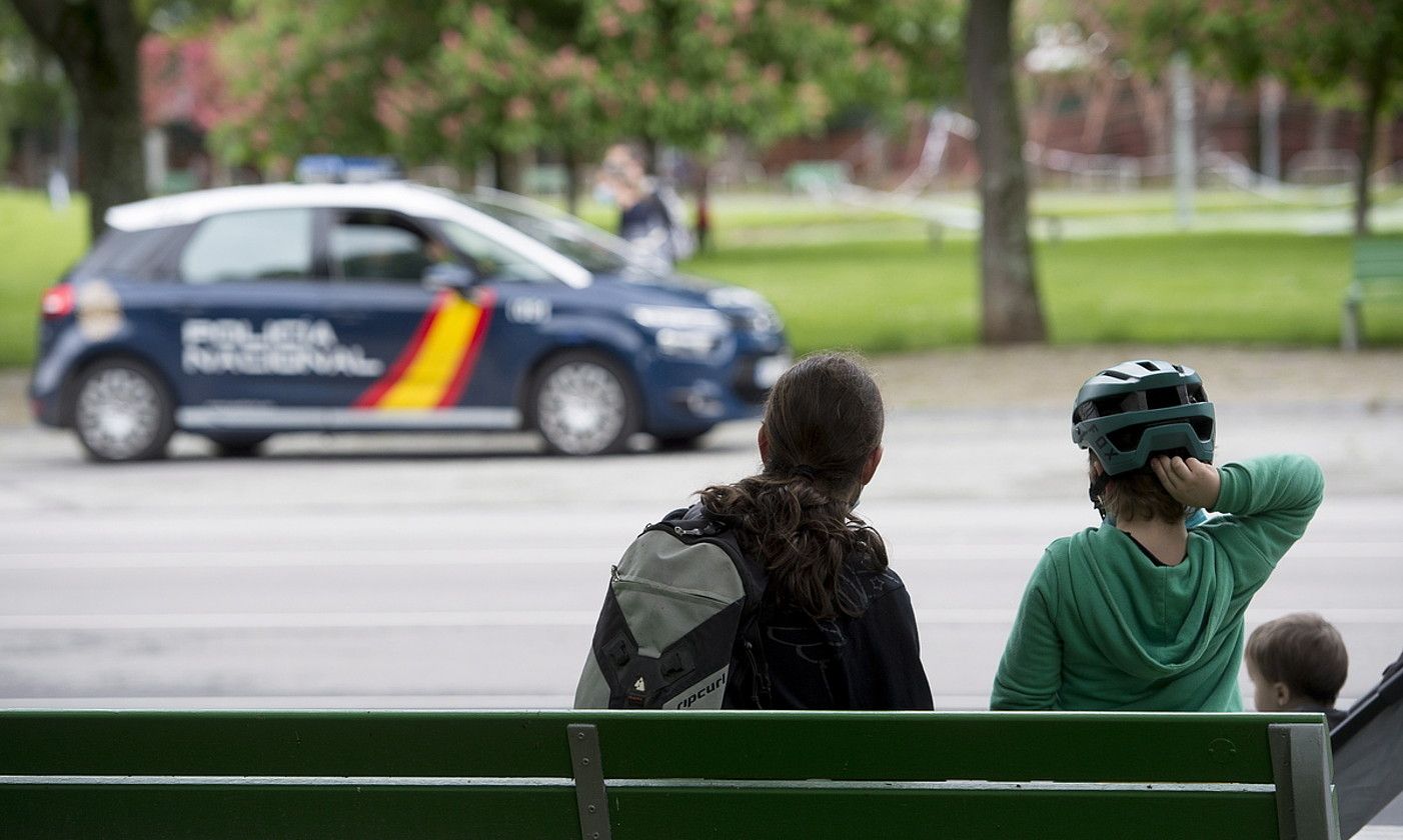 Familia bateko hiru kide Iruñeko parke batean, aurrean Espainiako Polizia dutela. IÑIGO URIZ / FOKU.