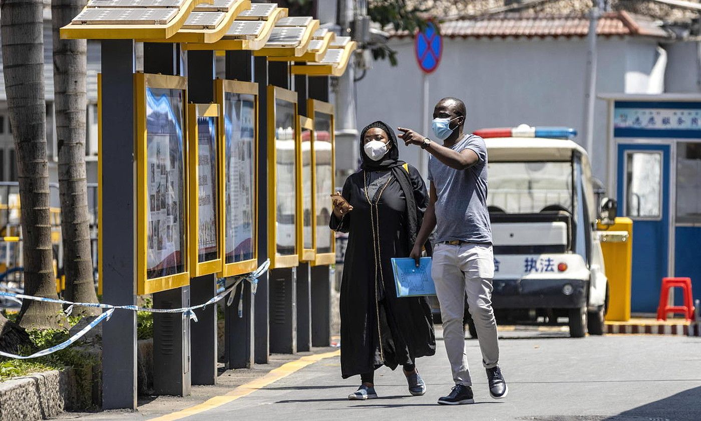 Bikote afrikar bat, maskarak soinean, Guangzhou hiriko Herrixka Afrikarrean. ALEX PLAVEVSKI / EFE.