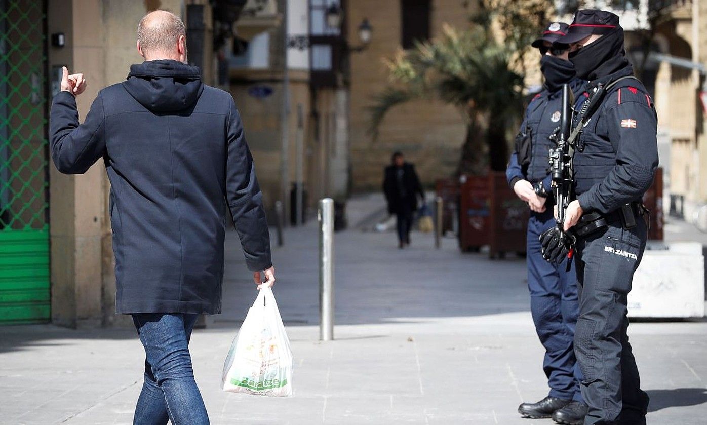 Ertzaintza eta herritar bat, Donostian, konfinamendu hasieran. JAVIER ETXEZARRETA / EFE.