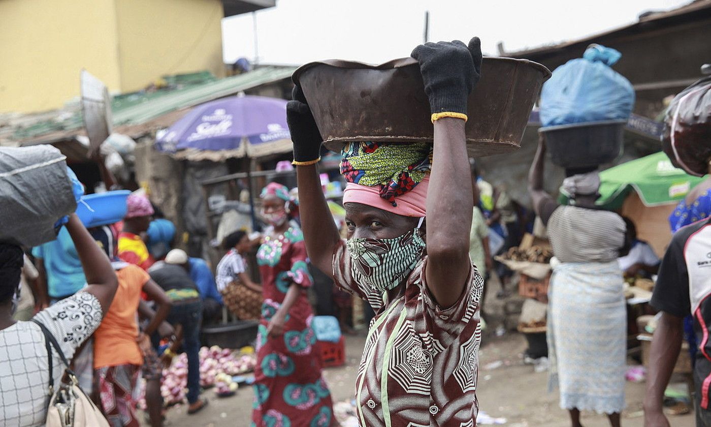 Emakume bat koronabirusetik babesteko maskara soinean duela, Nigeriako Lagos hiriburuko merkatu batean. AKINTUNDE AKINLEYE / EFE.