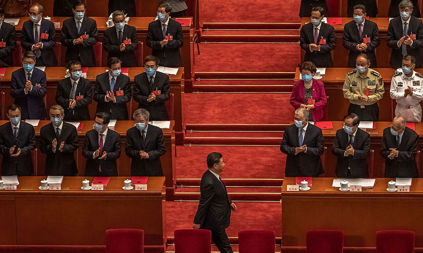 Xi Jinping, Txinako presidentea, parlamentuan, txaloka ari diren diputatuen aurretik igarotzen, atzoko osoko bilkuran. ROMAN PILIPEY / EFE.