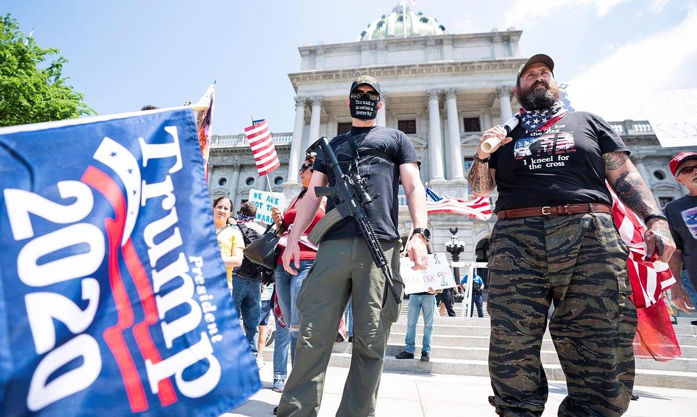 Eskuin muturreko jarraitzaileak, Michigan estatuko kapitolioaren parean, armak aldean, konfinamenduaren kontrako protesta batean, joan den maiatzean. JIM LO SCALZO / EFE. Eskuin muturreko jarraitzaileak, Michigan estatuko kapitolioaren parean, armak aldean, konfinamenduaren kontrako protesta batean, joan den maiatzean. JIM LO SCALZO / EFE.