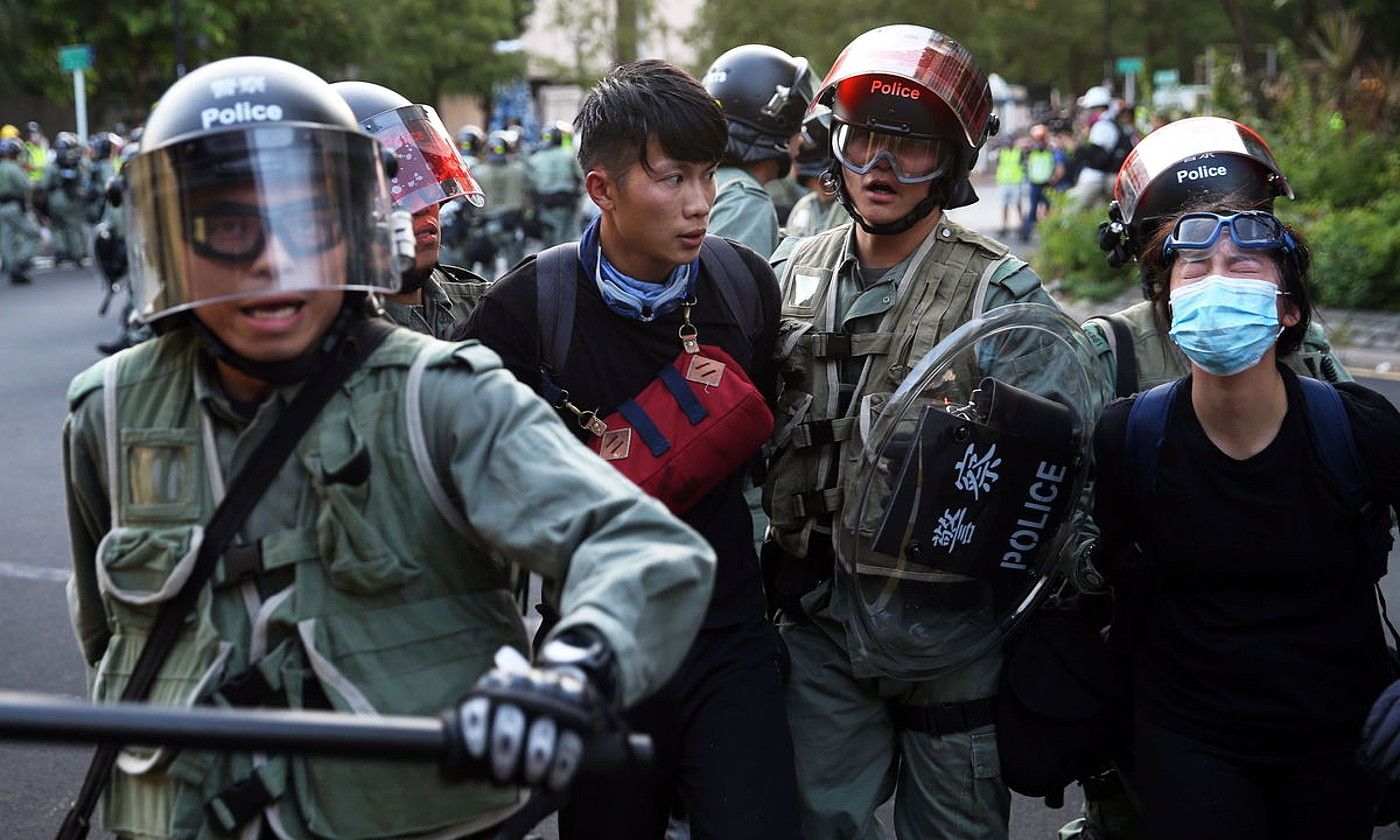 Txinako Polizia bi manifestari atxilotzen, Hong Kongen autonomiaren aldeko protesta batean, joan den irailean. JEROME FAVRE / EFE.
