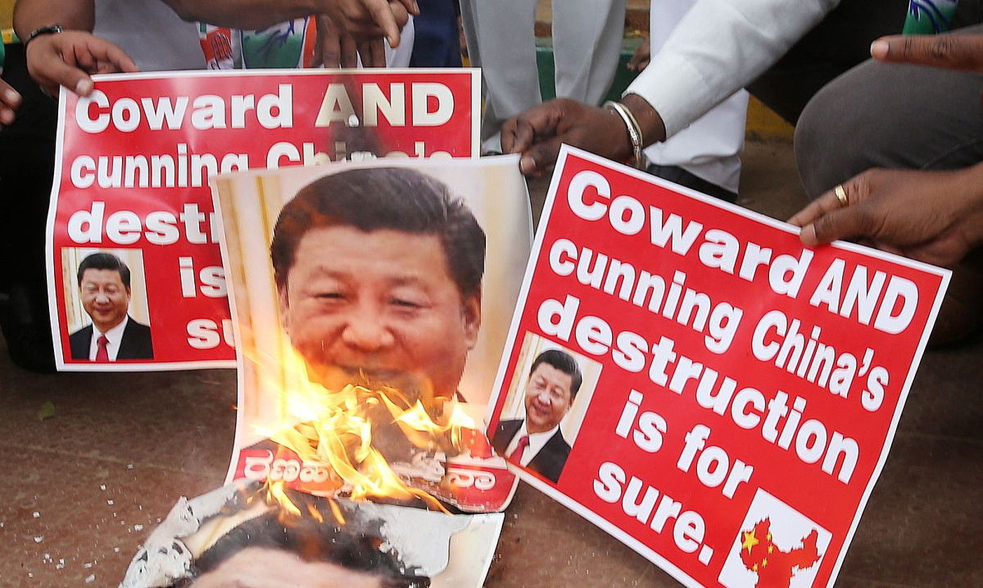 Manifestariak Xi Jinping Txinako presidentearen argazkiak erretzen, Bangaloren, Indian. JAGADEESH NV / EFE.