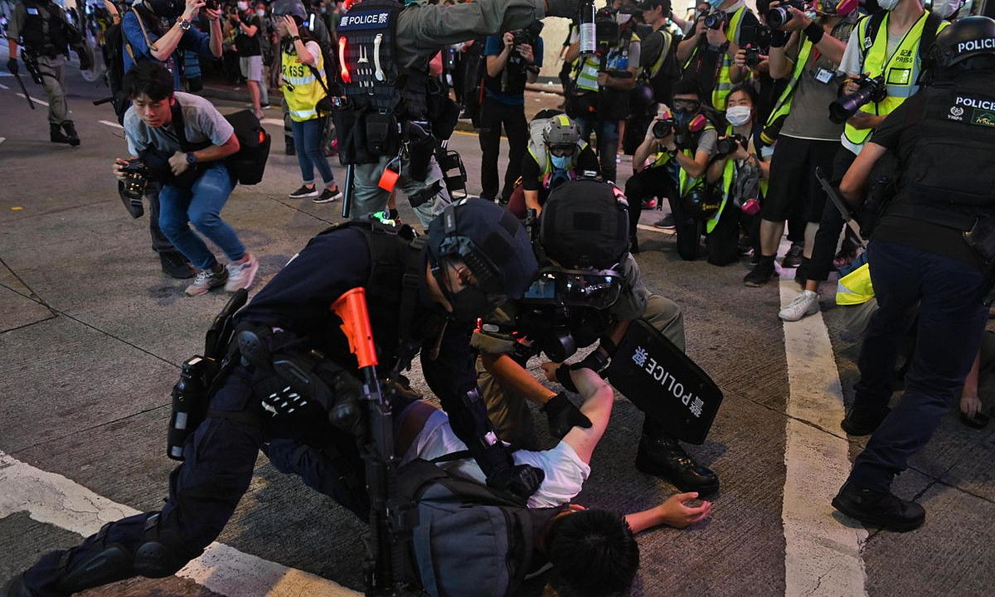 Polizia manifestari bat atxilotzen, atzo, Hong Kongen. Segurtasun indarren arabera, 300dik gora izan ziren atxilotuak. MIGUEL CANDELA / EFE.