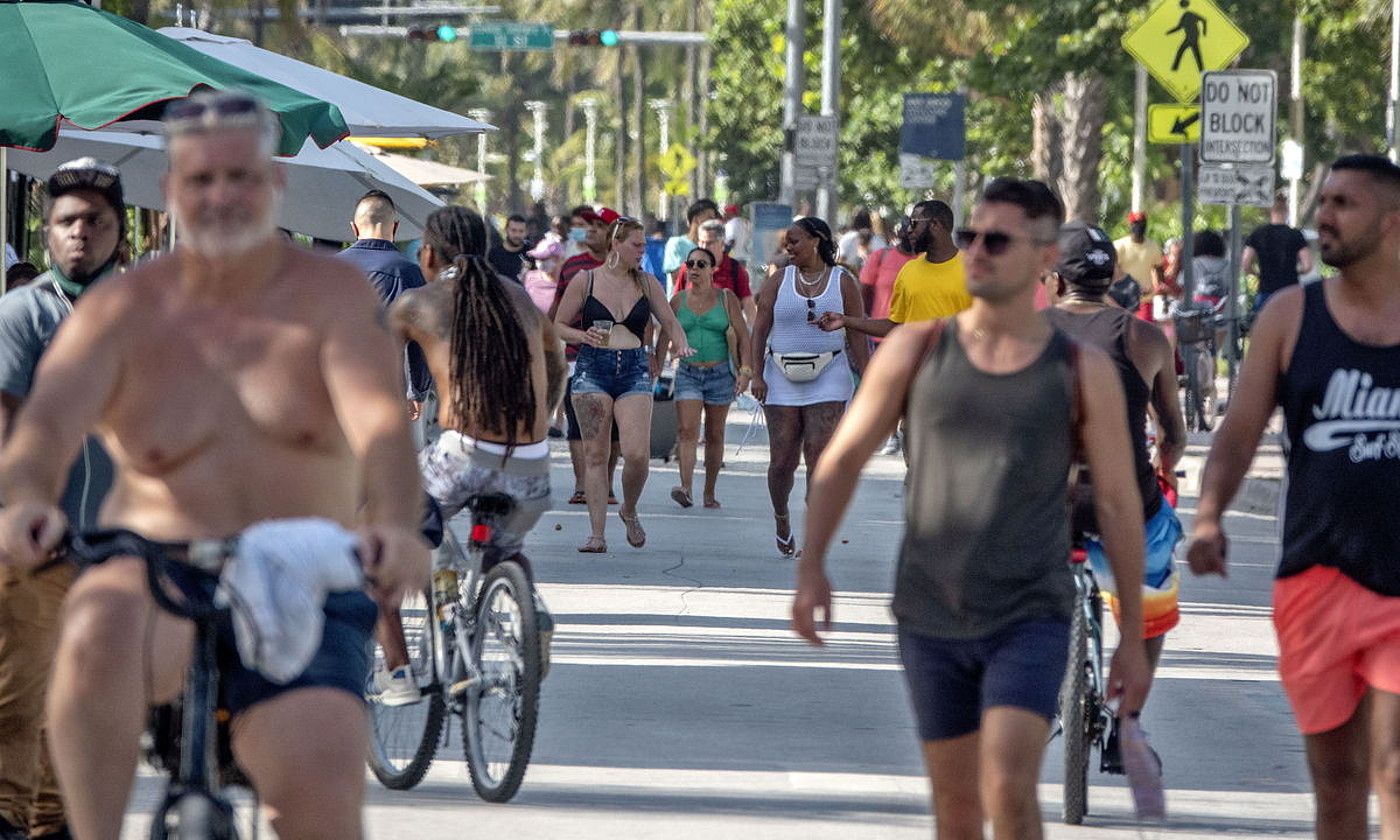 Jendea Miamiko hondartza ondoan paseatzen, birusaren hedatzearengatik neurriak gogortu behar izan dituen AEBetako Florida estatuan. CRISTOBAL HERRERA / EFE.