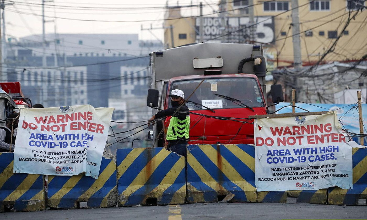 Errepidea blokeatuta Manilan, kasu kopuru handiaren ohartarazpena egiten duen kartel batekin. FRANCIS R. MALASIG / EFE.