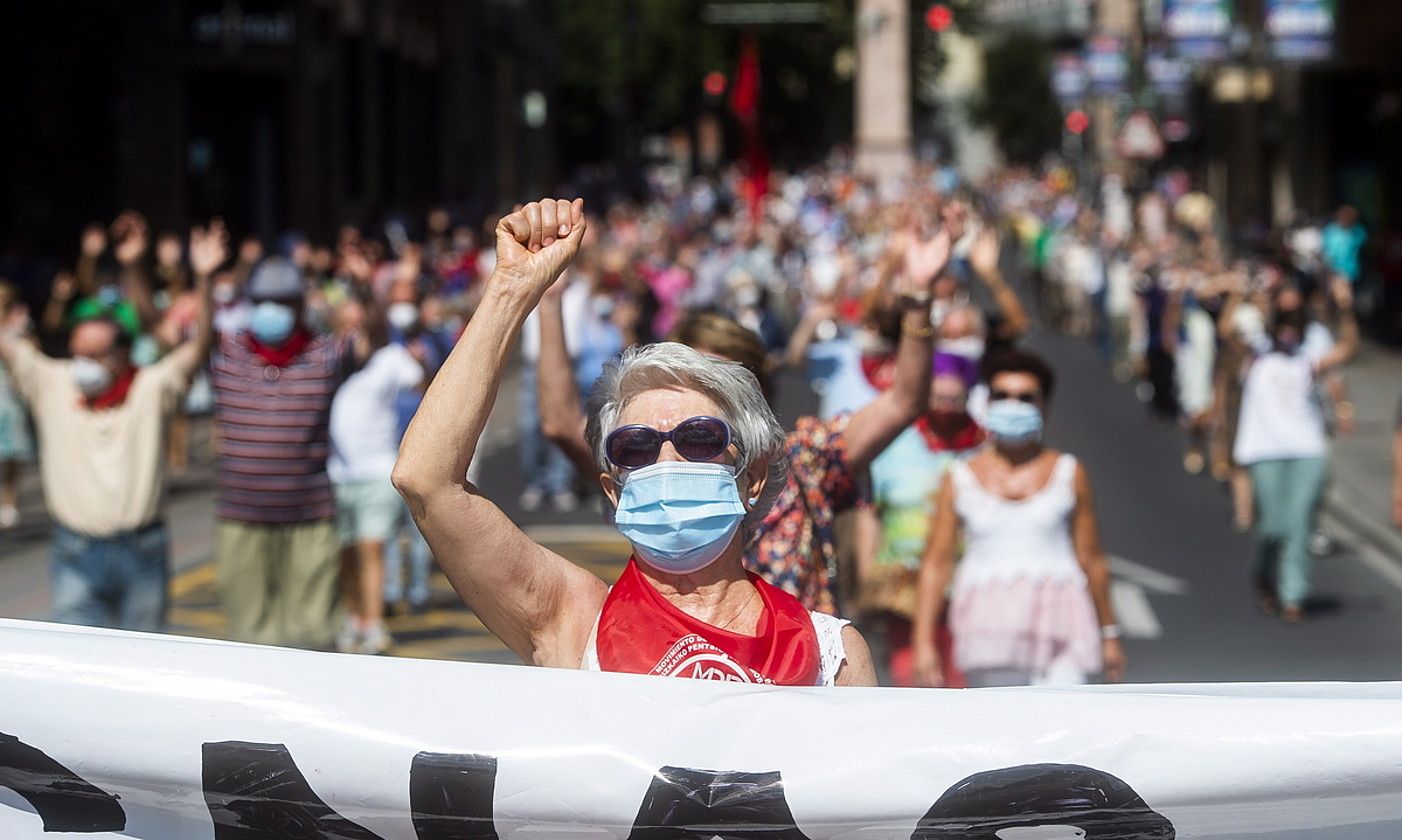 Pentsiodunen manifestazioko pankarta zeraman emakume bat, ukabila altxatuta, Bilboko Kale Nagusian barrena. LUIS JAUREGIALTZO / FOKU.