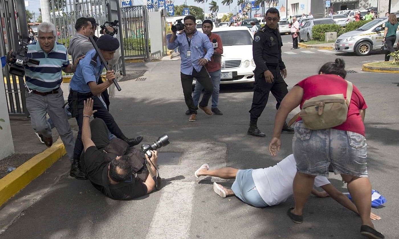 Nikaraguako poliziak preso politikoen aldeko manifestazio baten berri ematen ari zen Oscar Navarrete kazetaria jotzen, joan den abenduan. JORGE TORRES / EFE.