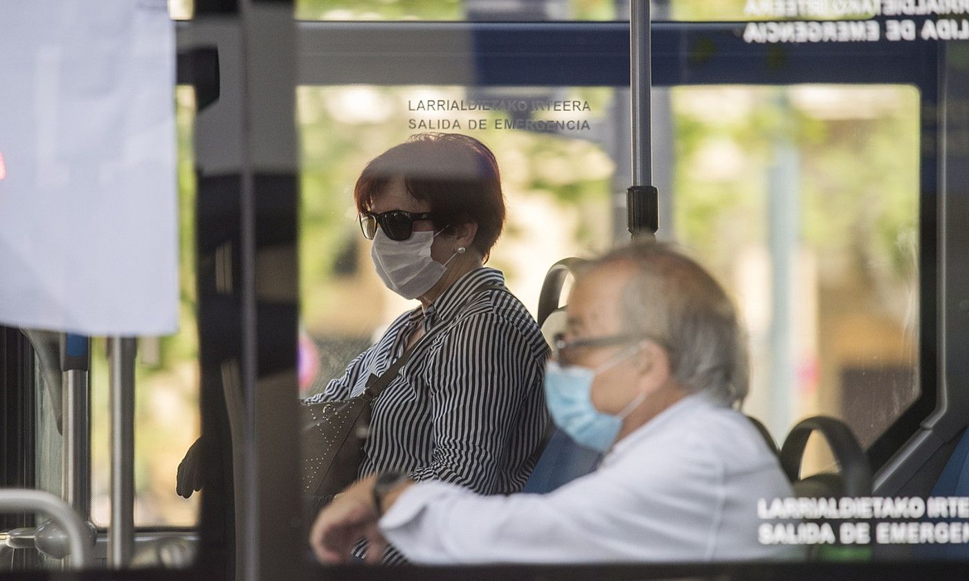 Bi pertsona maskarak soinean daramatzatela, autobusean. JUAN CARLOS RUIZ / FOKU.