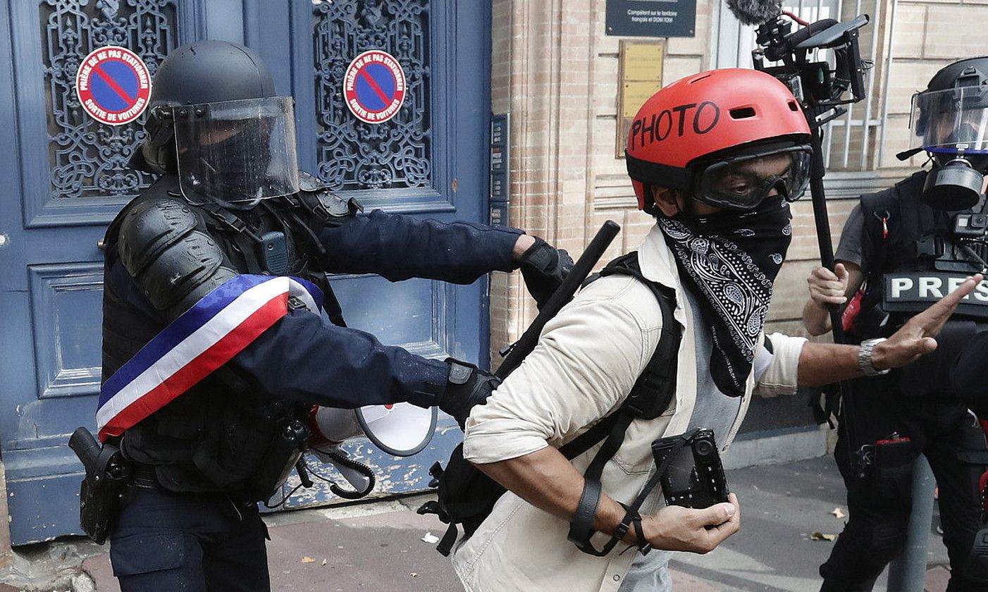 Frantziako polizia bat, argazkilari bat Jaka Horien manifestaziotik botatzen. GUILLAUME HORCAJUELO/EFE.