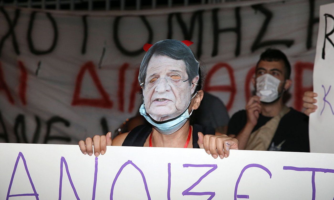 Manifestari bat, Zipreko presidente Nikos Anastasiades-en aurpegia irudikatzen duen maskara jantzita, asteazkenean, parlamentuaren pareko protestan. KATIA KHRISTODULU / EFE.