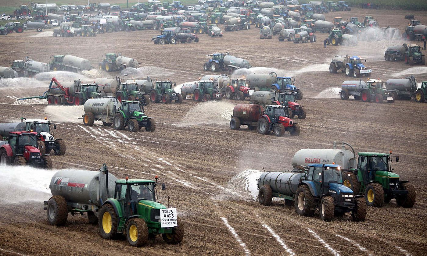 Nekazarien protestak.  2009an kuoten kalkuluan huts egin zuen Bruselak. Esnea sobera, prezioak amildu ziren. Irudian, nekazariak esnea soroetan jaurtitzen, Belgikan. OLIVIER HOSLET / EFE.