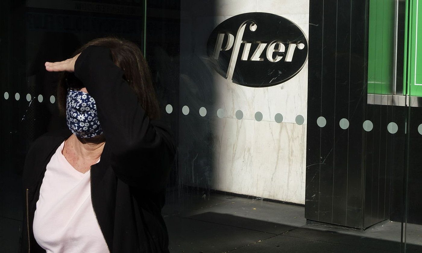 Pertsona bat, maskara jantzita, Pfizer konpainiaren parean. J. LANE / EFE.