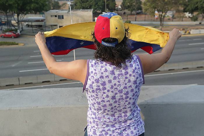 Herritar bat, Venezuelako banderarekin La Carlota armadaren egoitzan. RAYNER PEñA, EFE