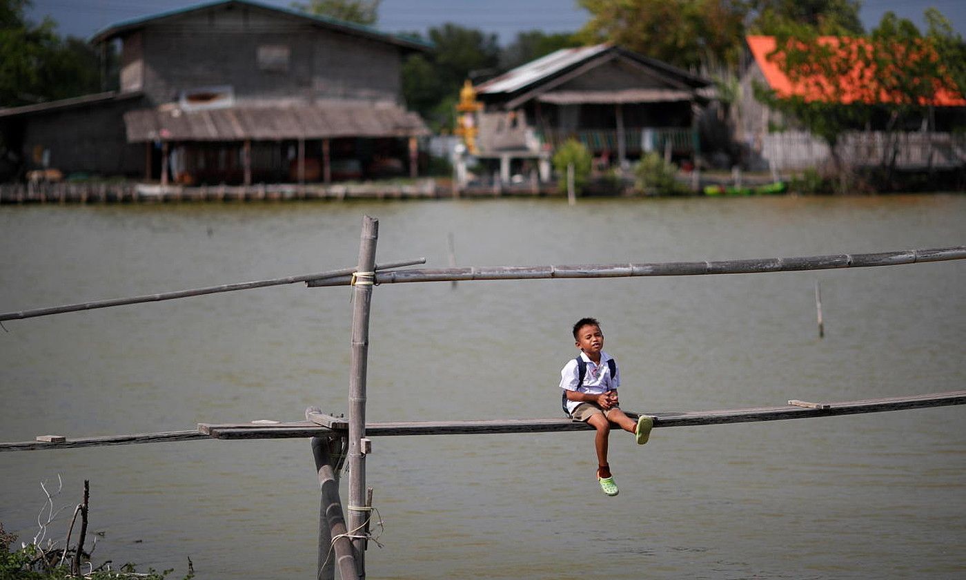 Haur bat Thailandiako Ban Khun Samut Chinen. Klima larrialdiak itsasoaren maila igotzea eragin du han. R. YONGRIT / EFE.