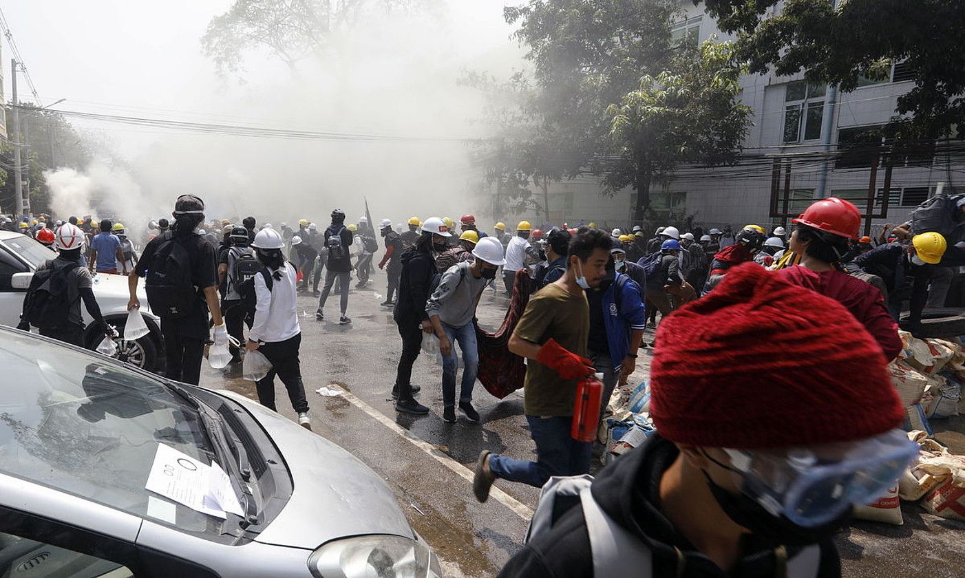Hainbat manifestari, segurtasun indarrek jaurtitako negar gasetik ihesi, Yangon hirian. NYEIN CHAN NAING / EFE.