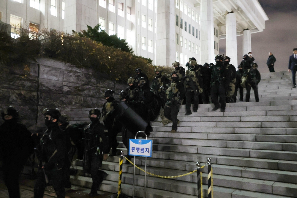 Militarrak parlamentuaren eraikinetik ateratzen, diputatuek legea indargabetzearen alde bozkatu ostean. YONHAP / EFE Militarrak parlamentuaren eraikinetik ateratzen, diputatuek legea indargabetzearen alde bozkatu ostean. YONHAP / EFE