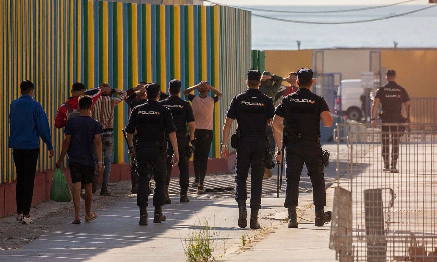 Espainiako Polizia, atzo, migratzaile talde bat eramaten, Ceutan. BRAIS LORENZO / EFE.