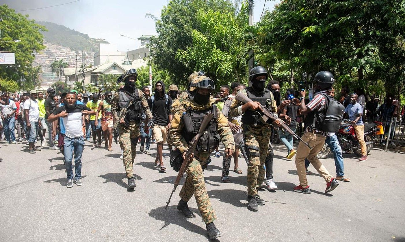 Haitiko Polizia, atxilotuetako bat herritarrengandik banandu nahian, atzo, Port-au-Princen. JEAN MARC HERVE ABELARD / EFE.