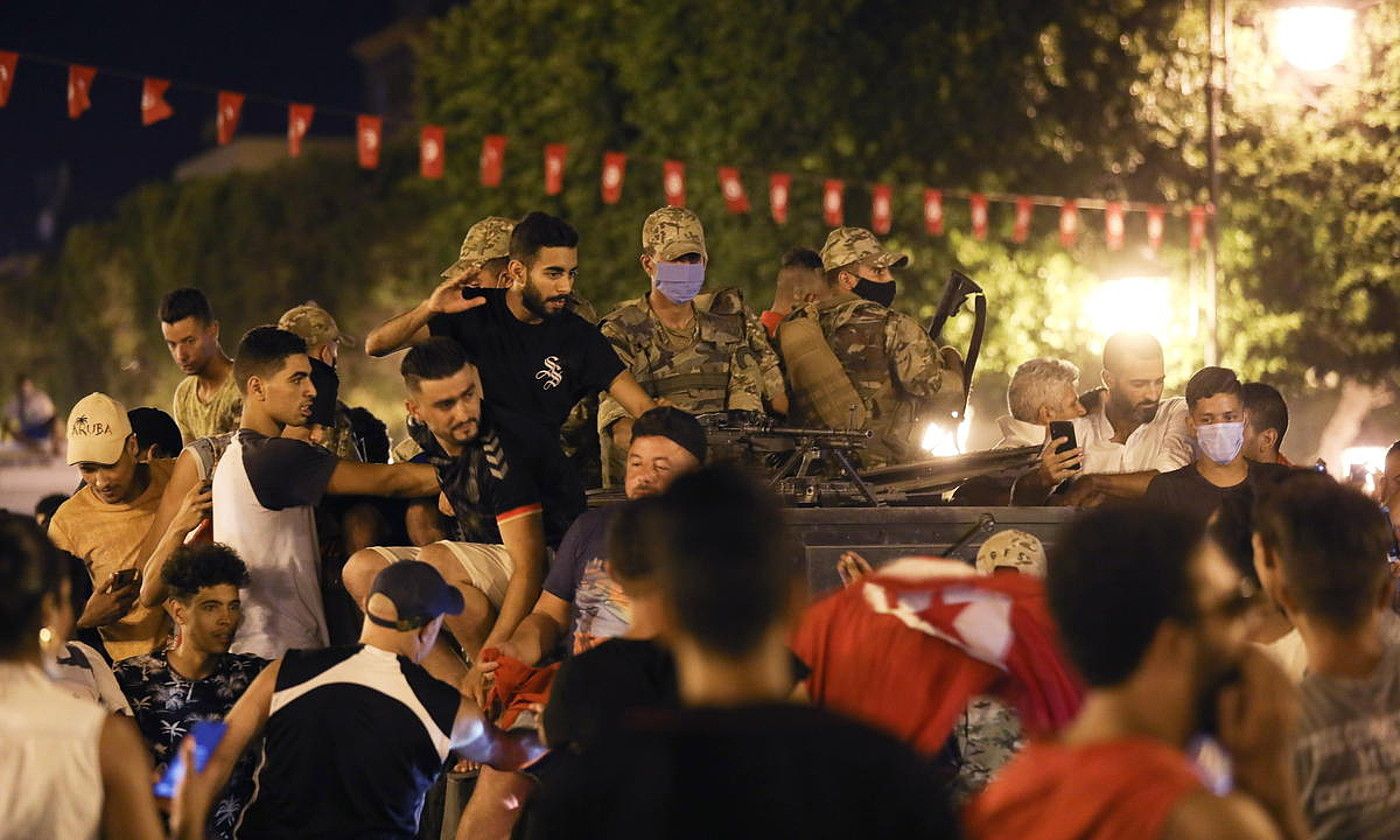 Kais Saied Tunisiako presidentearen jarraitzaileak kalean, hark hartutako erabakiak ospatzen, igande gauean. STR / EFE. Kais Saied Tunisiako presidentearen jarraitzaileak kalean, hark hartutako erabakiak ospatzen, igande gauean. STR / EFE.