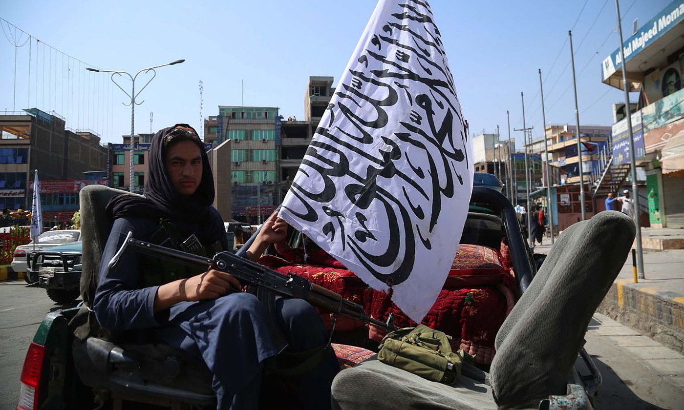 Taliban bat ibilgailu batean, taldearen bandera eta arma bat eskuetan dituela, Jalalabaden. STRINGER / EFE.