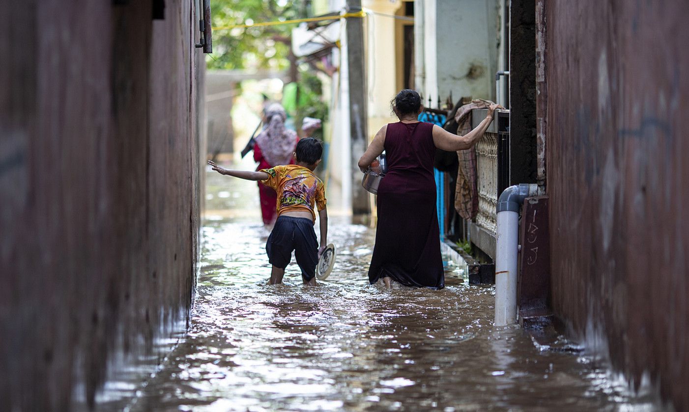 Bi pertsona hankak uretan dituztela, Jakartan, iragan otsailean. UNICEF.